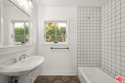 a bathroom with a bathtub and next to a window