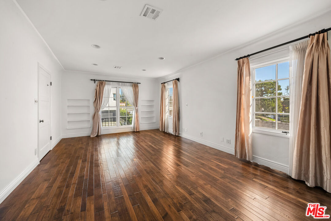 1849 Benecia Avenue Los Angeles, CA 90025 - Photo 32 of 59 an empty room with wooden floor and windows