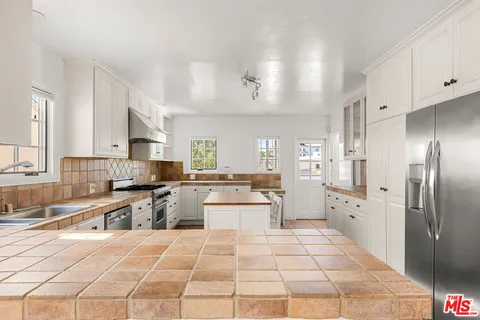 a large white kitchen with cabinets