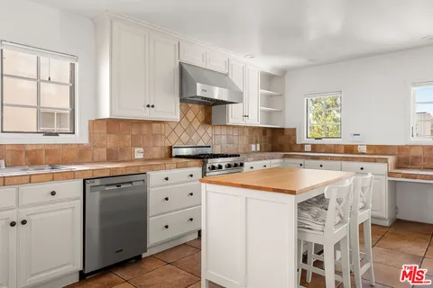 a kitchen with cabinets appliances a sink and a window