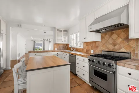 a kitchen with granite countertop a sink and a stove top oven