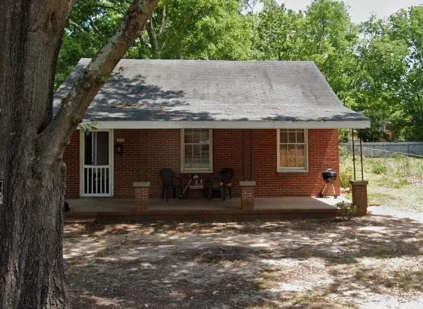 a front view of house with yard outdoor seating and covered with green space