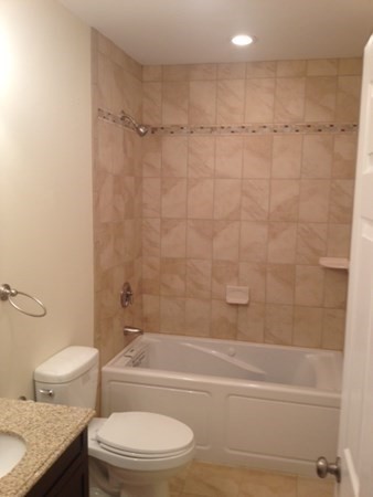 26 Maverick Street, Unit 1 Boston, MA 02128 - Photo 8 of 8 a bathroom with a granite countertop bathtub shower sink vanity and toilet