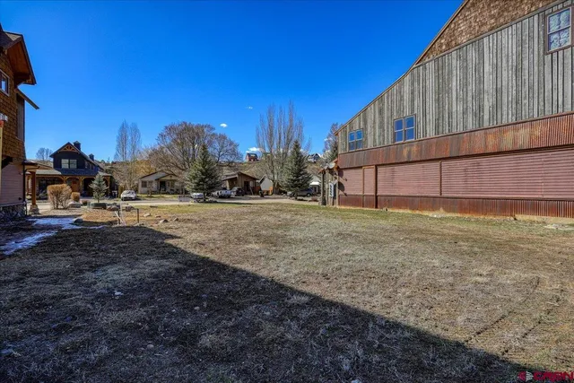 a view of a house with backyard and trees