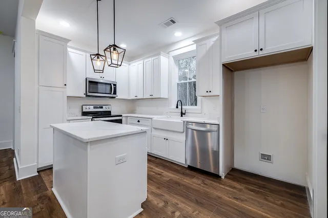 a kitchen with appliances cabinets a sink and a counter top space