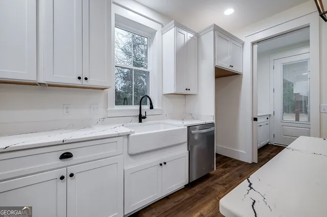 a kitchen with white cabinets and sink