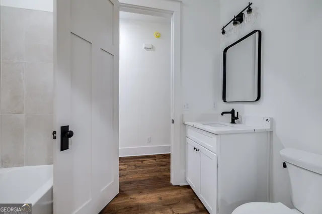 a bathroom with a sink and mirror with toilet