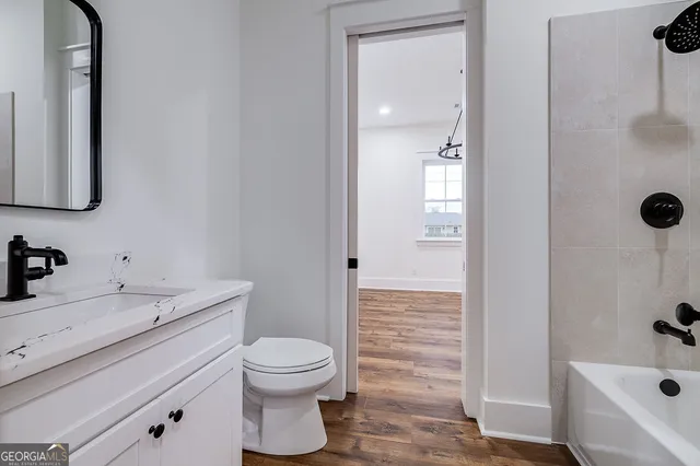 a bathroom with a sink a toilet and shower