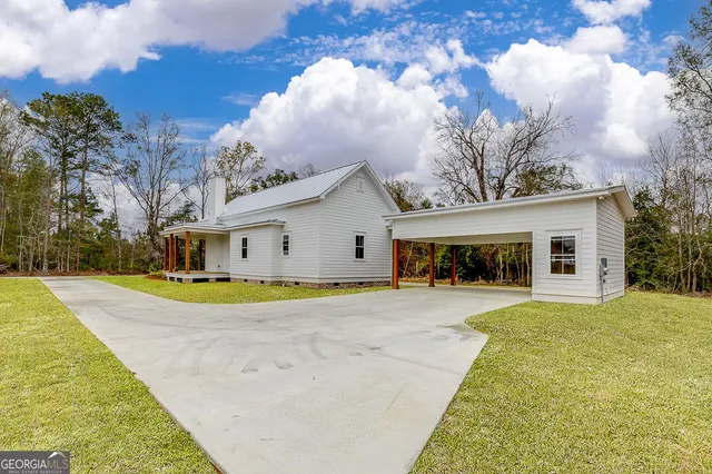 a view of a house with a backyard and a tree