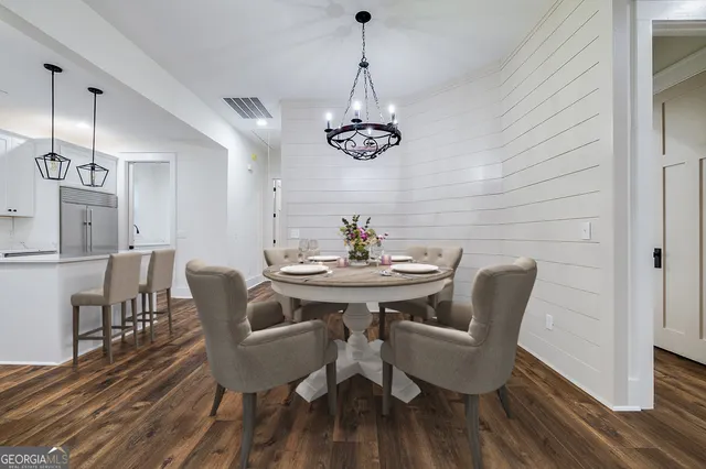 a view of a dining room with furniture wooden floor and chandelier