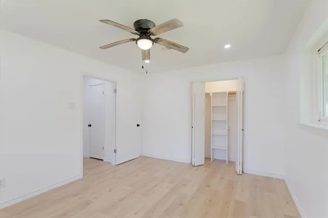 a view of an empty room with a chandelier fan