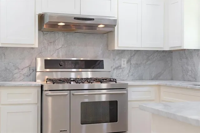 a stove top oven sitting inside of a kitchen