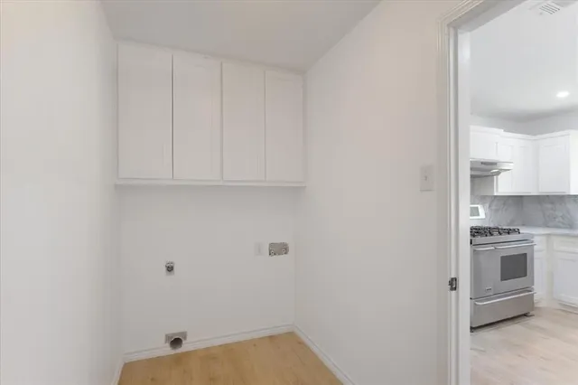 a view of a kitchen with white cabinets and stainless steel appliances