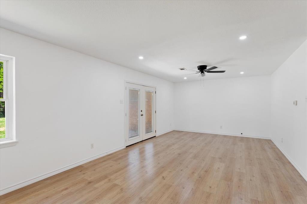 Undisclosed Address Howe, TX 75459 - Photo 4 of 29 an empty room with wooden floor and windows