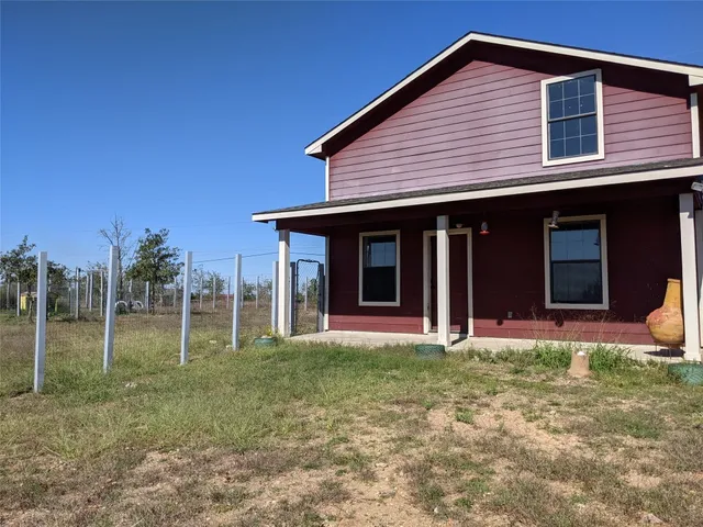 a view of a house with backyard and porch