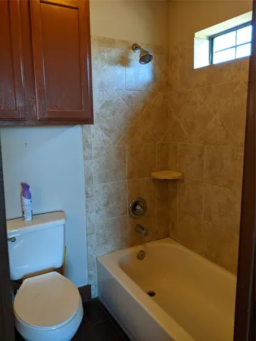 a white toilet sitting next to a bath tub