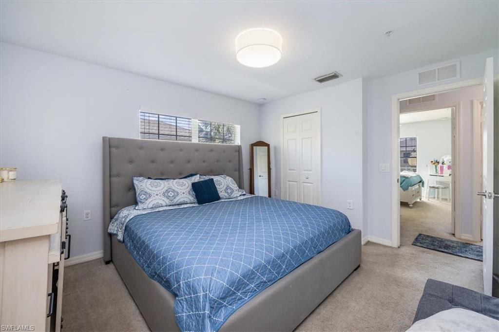 9072 Gervais Circle, Unit 307 Naples, FL 34120 - Photo 11 of 32 a bedroom with a bed and closet