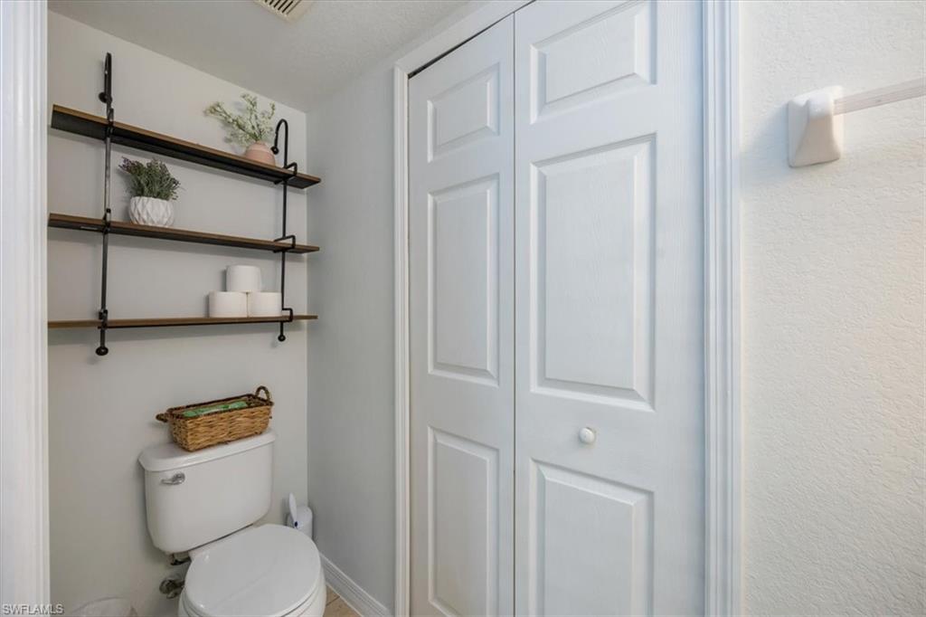 9072 Gervais Circle, Unit 307 Naples, FL 34120 - Photo 13 of 32 a white toilet sitting next to a bathroom sink