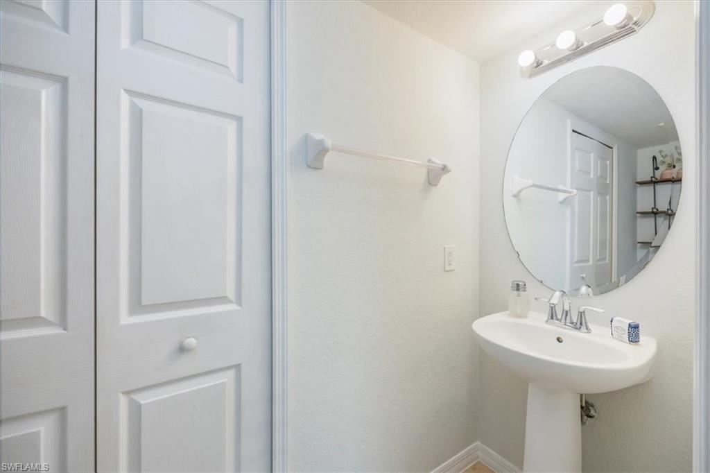 9072 Gervais Circle, Unit 307 Naples, FL 34120 - Photo 14 of 32 a bathroom with a sink a mirror and shower