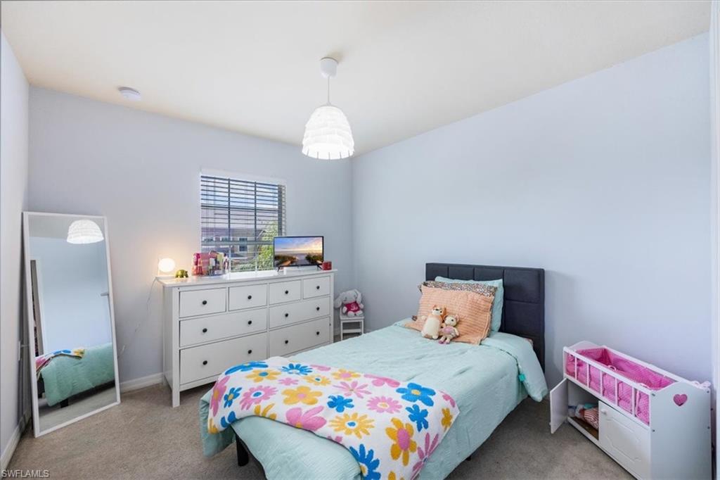 9072 Gervais Circle, Unit 307 Naples, FL 34120 - Photo 16 of 32 a bedroom with a bed and a dresser