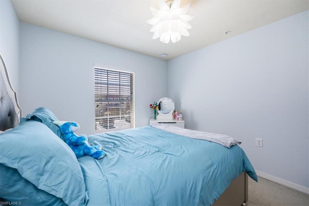 9072 Gervais Circle, Unit 307 Naples, FL 34120 - Photo 18 of 32 a bedroom with a bed and a window