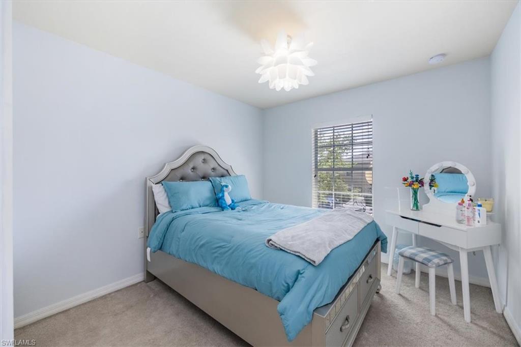 9072 Gervais Circle, Unit 307 Naples, FL 34120 - Photo 19 of 32 a bedroom with a bed and a table in it