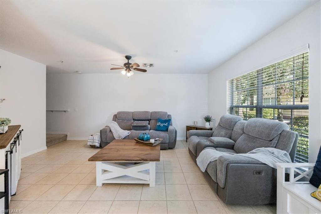 9072 Gervais Circle, Unit 307 Naples, FL 34120 - Photo 2 of 32 a living room with furniture and a floor to ceiling window