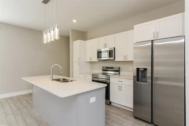 a kitchen with stainless steel appliances a refrigerator sink and microwave