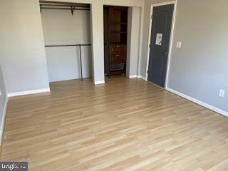 6907 Jones View Drive, Unit 3C Baltimore, MD 21209 - Photo 11 of 14 a view of an empty room with wooden floor and closet