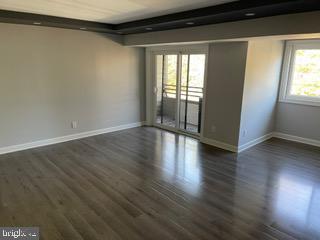 6907 Jones View Drive, Unit 3C Baltimore, MD 21209 - Photo 2 of 14 a view of an empty room with wooden floor and a window