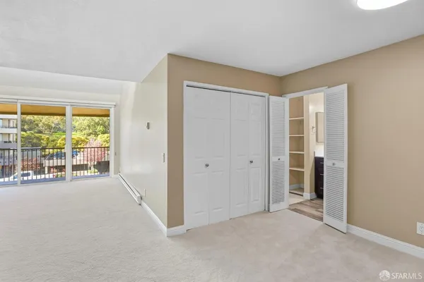 a view of a livingroom with wooden floor and a refrigerator