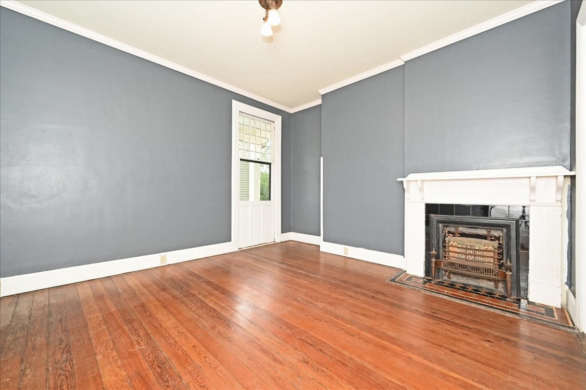 426 Sherman Street Southeast Decatur, AL 35601 - Photo 26 of 41 an empty room with wooden floor fireplace and windows