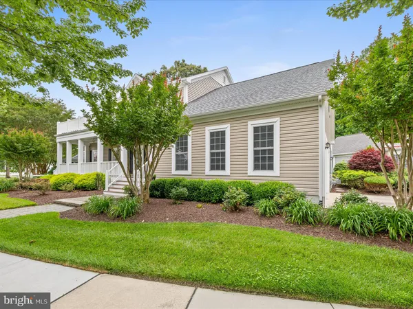 a front view of a house with a yard and potted plants