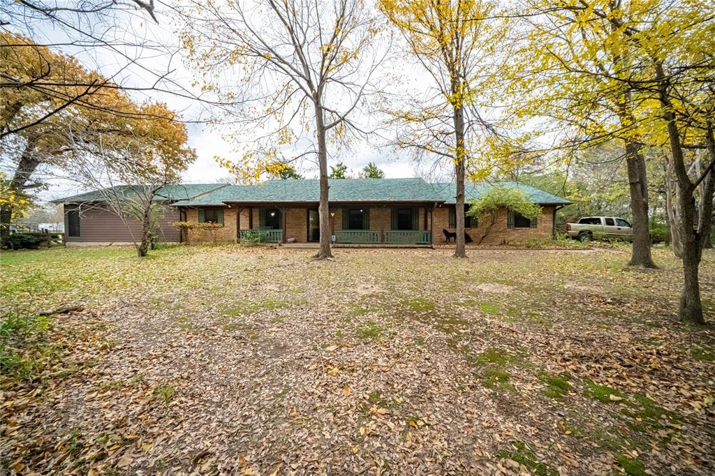 a front view of a house with a yard tree and wooden fence