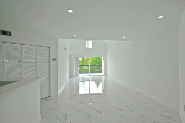 a view of a livingroom with a window and a kitchen