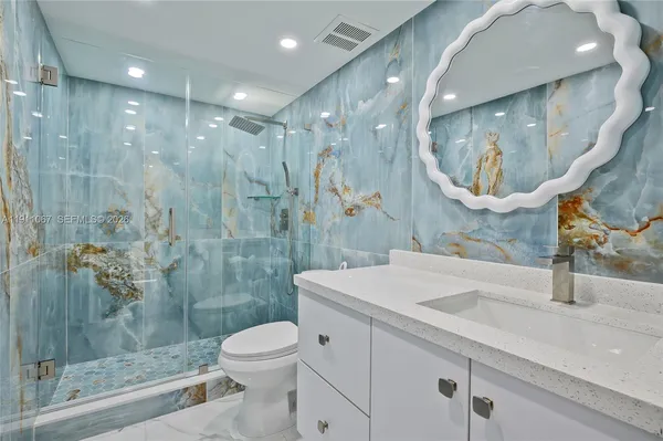 a bathroom with a sink a toilet and shower
