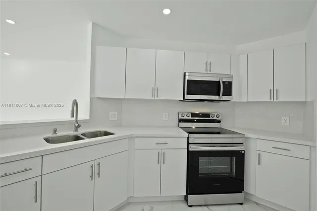 a kitchen with white cabinets and stainless steel appliances