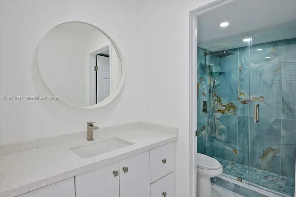 a bathroom with a sink a toilet and shower