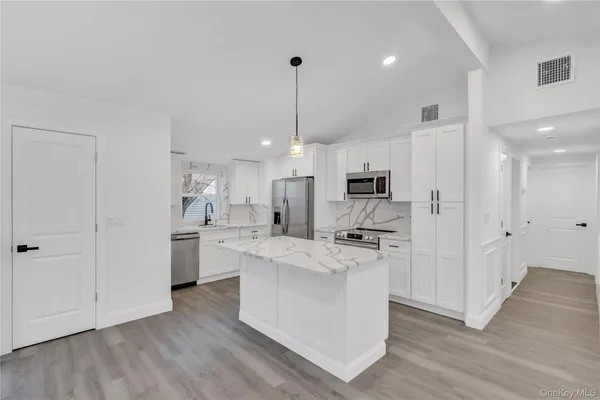 a kitchen with stainless steel appliances a stove refrigerator sink and microwave