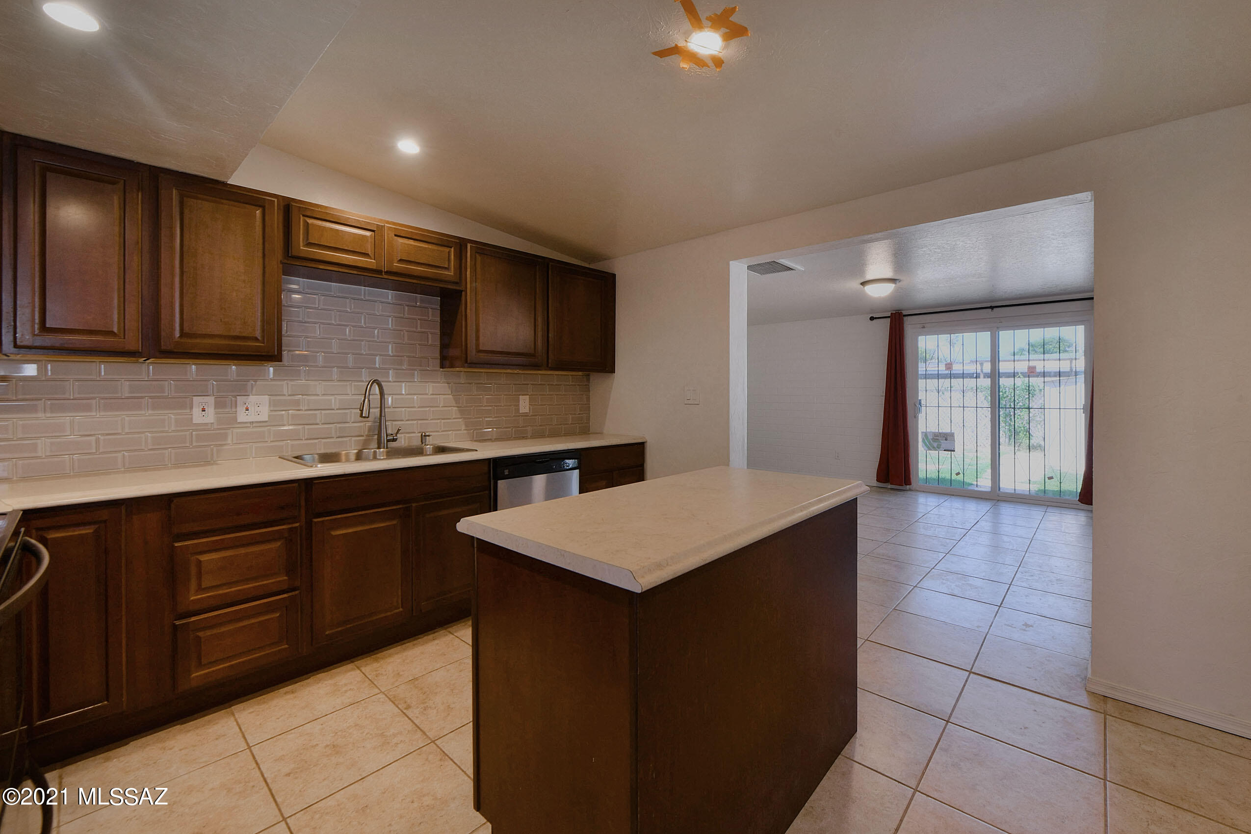 1470 West Roger Road Tucson, AZ 85705 - Photo 7 of 18 a kitchen with a sink a microwave and cabinets