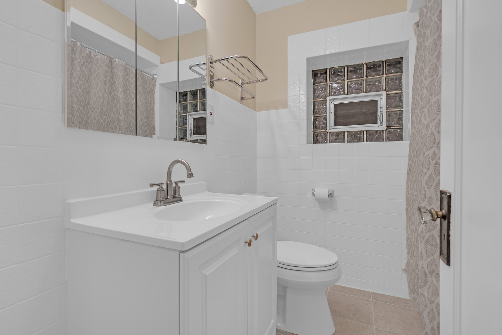 6138 North Meade Avenue Chicago, IL 60646 - Photo 13 of 32 a bathroom with a toilet a sink and mirror