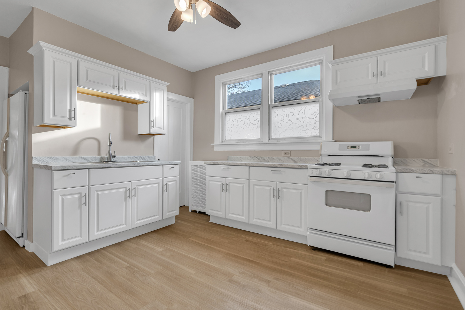 6138 North Meade Avenue Chicago, IL 60646 - Photo 23 of 32 a kitchen with stainless steel appliances granite countertop white cabinets sink and window