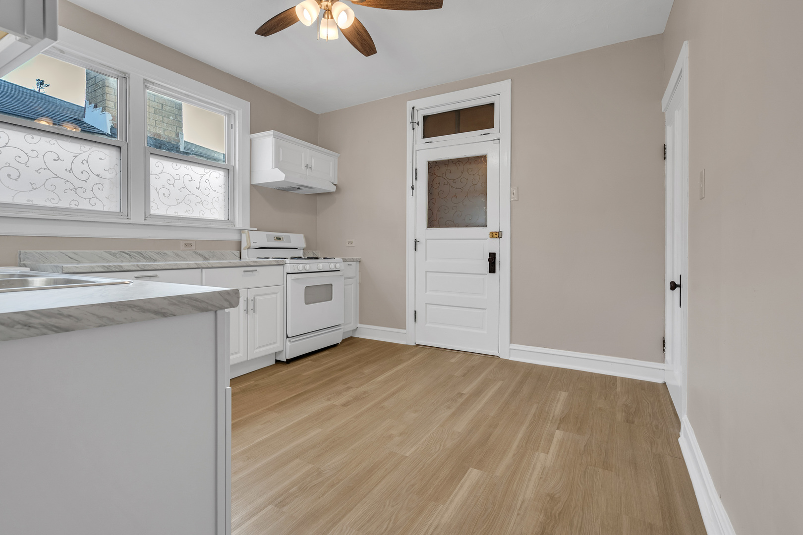 6138 North Meade Avenue Chicago, IL 60646 - Photo 25 of 32 a kitchen with a sink cabinets stainless steel appliances and a window