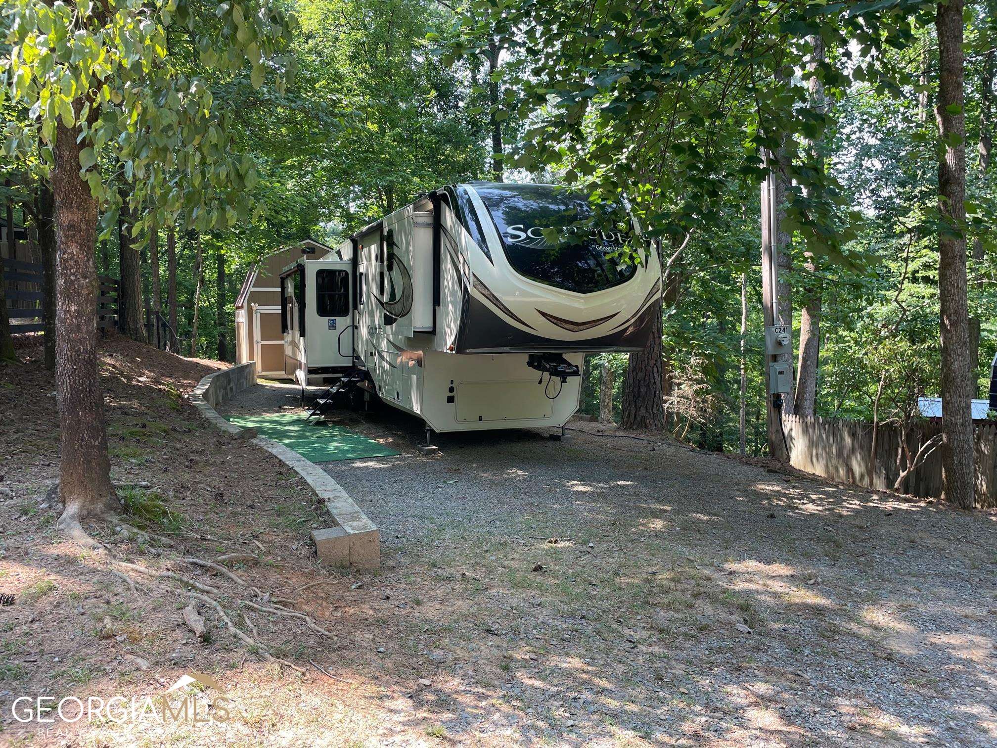 a view of a house with a backyard and trees