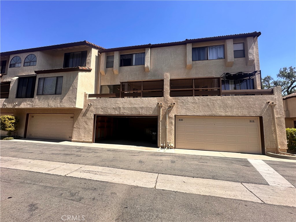 7 Wilderness Place Pomona, CA 91766 - Photo 25 of 26 a front view of a house with a garage