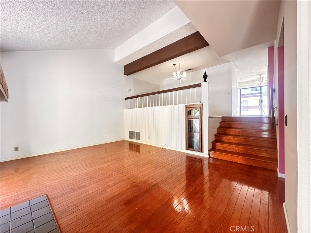7 Wilderness Place Pomona, CA 91766 - Photo 5 of 26 a view of an empty room with wooden floor and stairs
