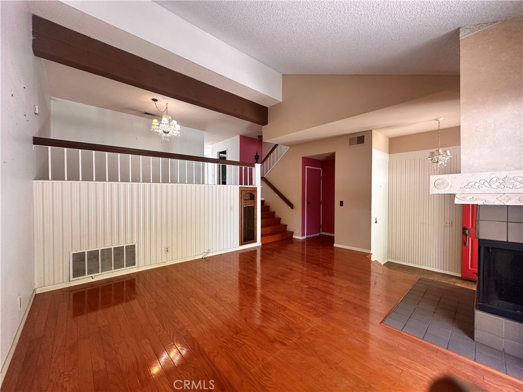 7 Wilderness Place Pomona, CA 91766 - Photo 6 of 26 a view of an empty room with wooden floor and a window