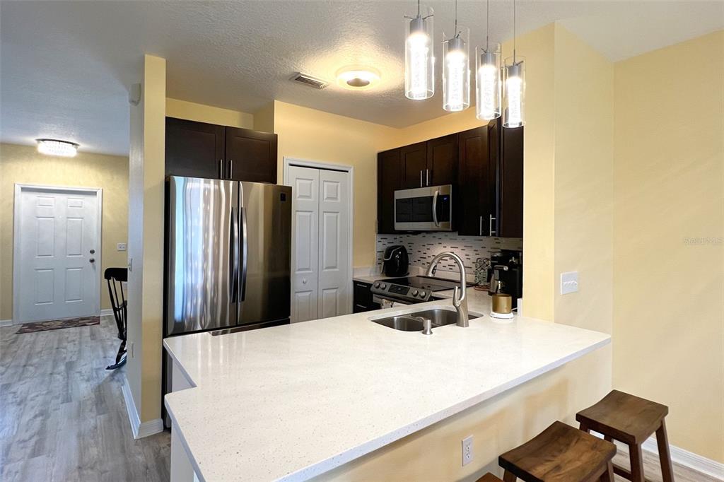 14741 Amberjack Terrace Lakewood Ranch, FL 34202 - Photo 8 of 48 a kitchen with a refrigerator a microwave a sink and chairs