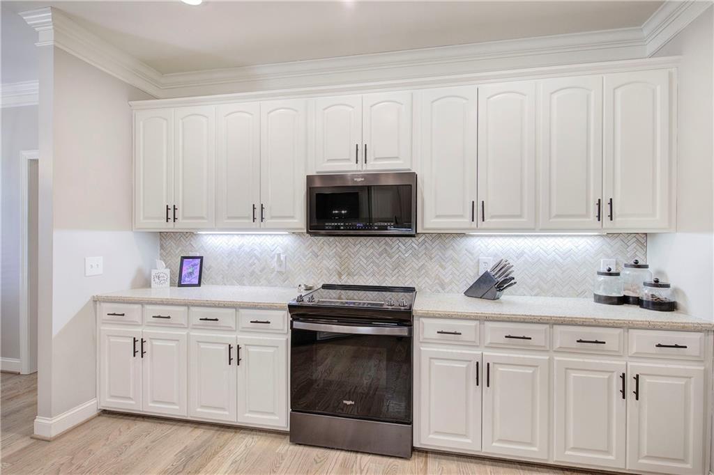 1005 Harmony Road Southeast Aragon, GA 30104 - Photo 15 of 40 a kitchen with white cabinets and stainless steel appliances
