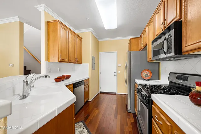 a kitchen with a sink a stove and a refrigerator